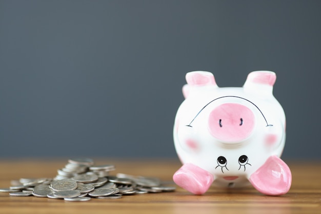 Coins and an upside down piggy bank lie on table