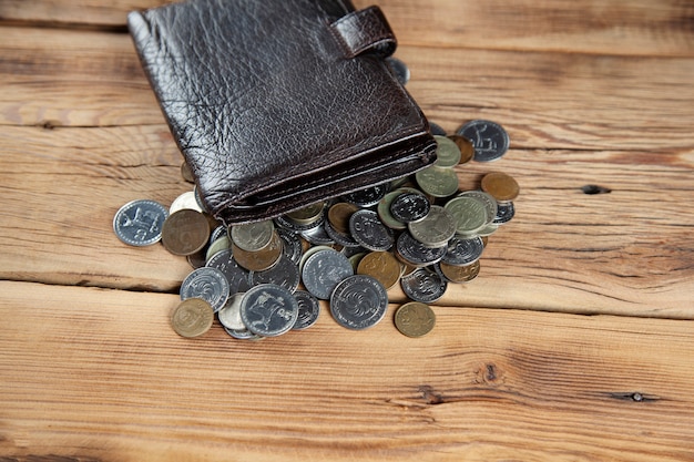 Coins and wallet on the wooden table