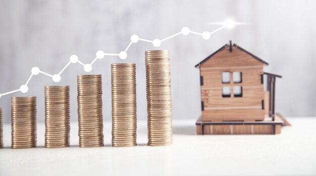 Coins with house model. Real Estate Graph. House market growth