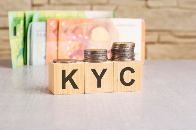 코인과 나무 큐브에 KYC (Know Your Customer) 라는 텍스트가 적혀 있습니다.