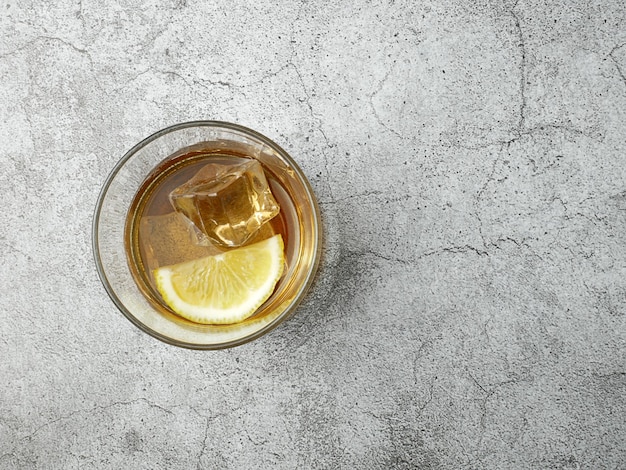 Cola drink with lemon on stone background