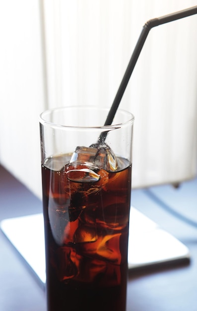 Cola glas met ijsblokjes op tafel