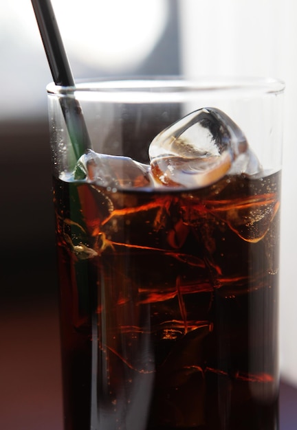 Cola glas met ijsblokjes op tafel