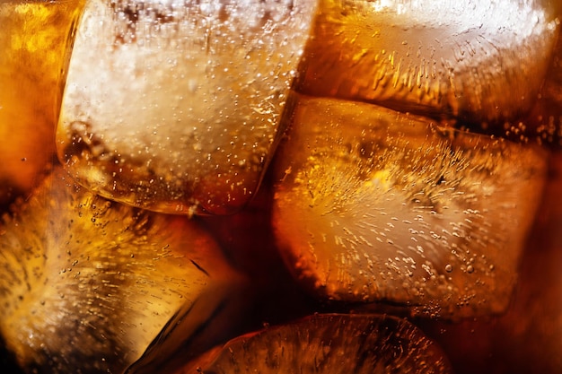 Cola and ice cubes macro texture Cola drink with ice closeup background