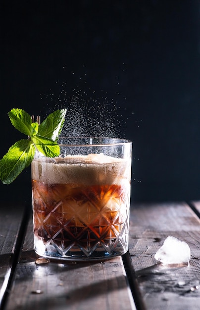 Cola is poured into a glass with ice