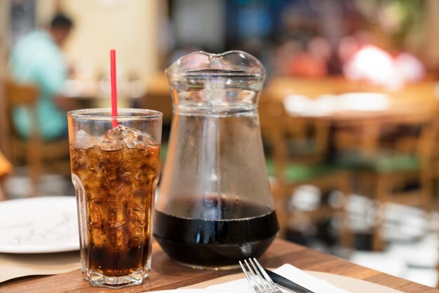 cola water and ice in glass with jar in restaurant