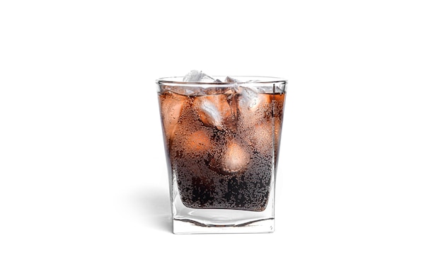 Cola with ice in a transparent glass isolated.