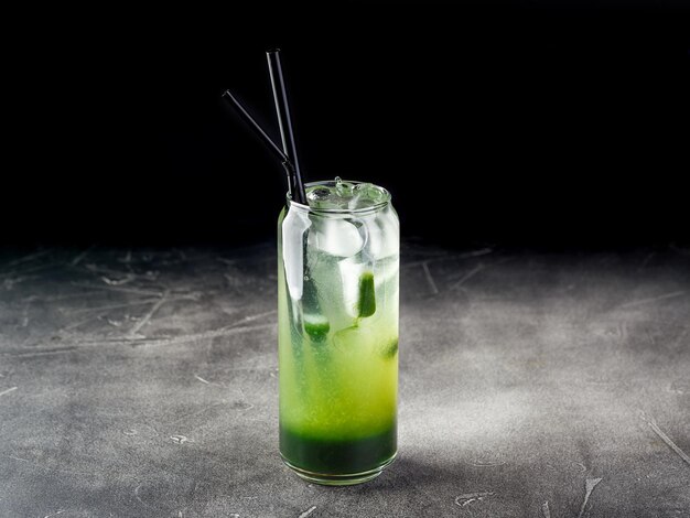 Cold alcoholic or nonalcoholic cocktail with ice on dark background