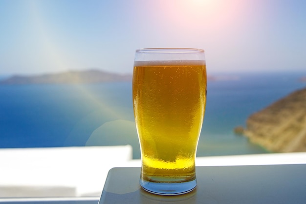 Cold beer glass on the blue sea background