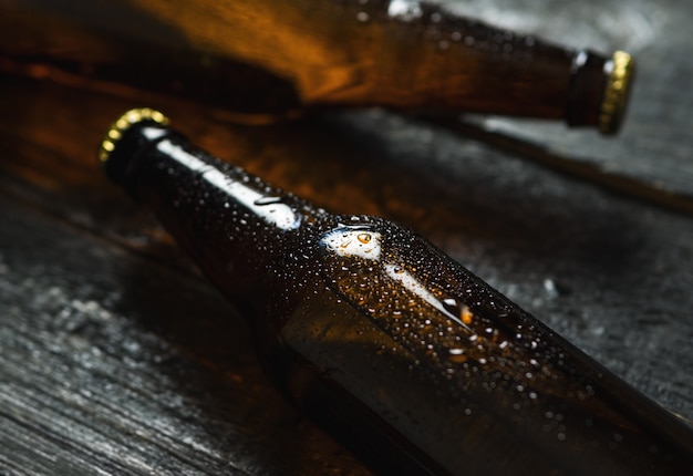 Cold beer in glass bottles on wooden table