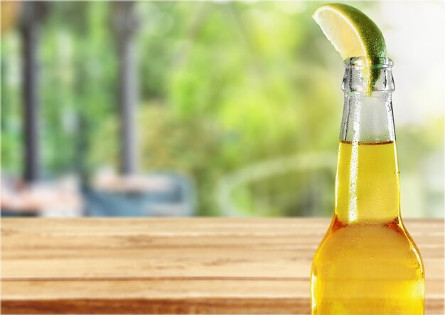 Cold beer with lime on background