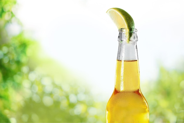 Cold beer with lime on background