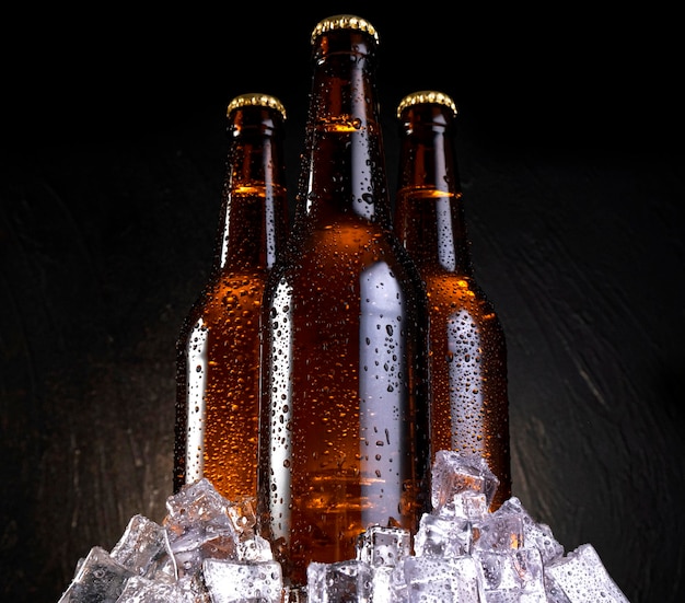 Cold beer with water drops beer bottles with ice cubes