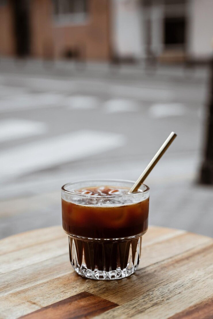 グラスで冷たい黒いアイスコーヒーを飲む