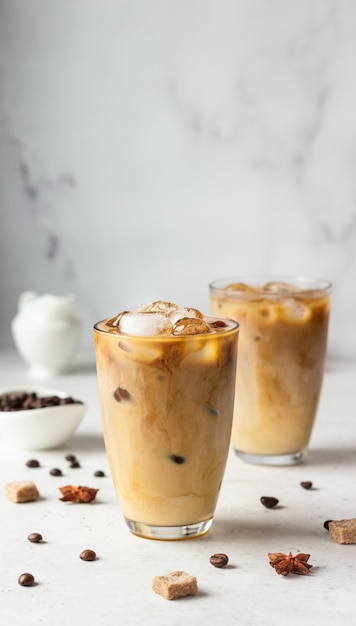 Photo cold brew coffee with spices and milk on light grey surface