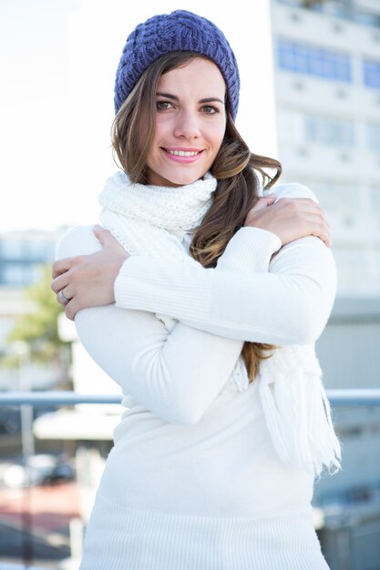 Cold brunette in warm clothes looking at camera 