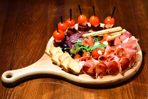 Cold cut platter. Wooden platter with cold meat cuts and canape. An oasis of pleasure