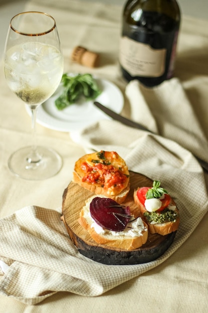 Cold drink and natural appetizer of vegetarian bruschetta with vegetables, cheese and herbs 