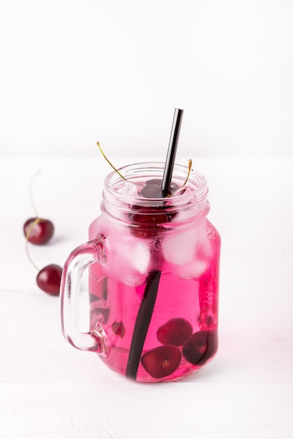 Cold Drink with Cherry in Jars on White Wooden Background Cold Detox Infused Water Summer Drink