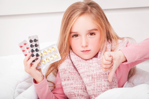 Cold and flu. A girl with pills in her hands