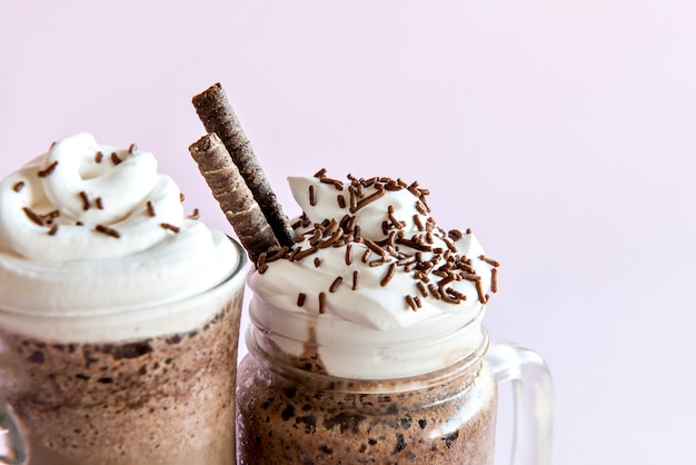 Photo cold frappe coffee with whipped cream. pink background with iced frappuccino.