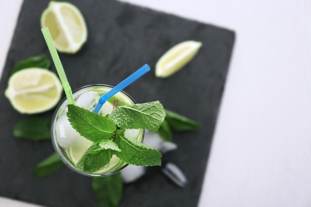 Cold fresh cocktail with lime on slate plate