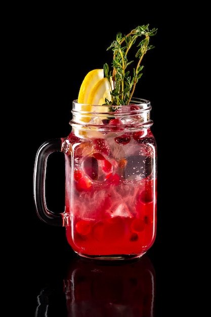 Cold fruit lemonade in mason jar isolated on black