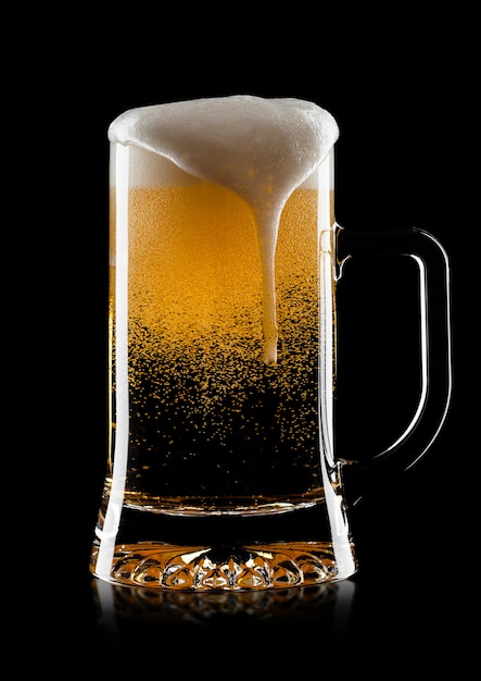 Cold glass of lager ale craft beer with foam and bubbles on black background