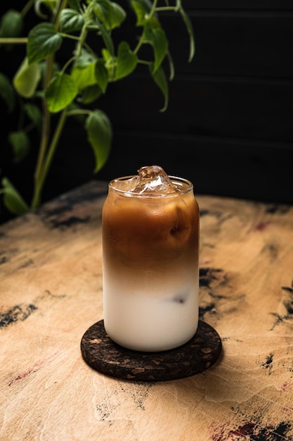 Caffè freddo freddo al latte un bicchiere highball alto riempito con una bevanda rinfrescante a strati di cubetti di ghiaccio