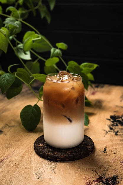 Caffè freddo freddo al latte un bicchiere highball alto riempito con una bevanda rinfrescante a strati di cubetti di ghiaccio