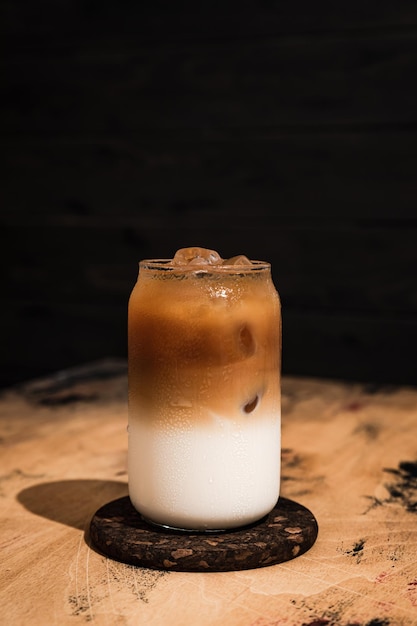 Caffè freddo freddo al latte un bicchiere highball alto riempito con una bevanda rinfrescante a strati di cubetti di ghiaccio