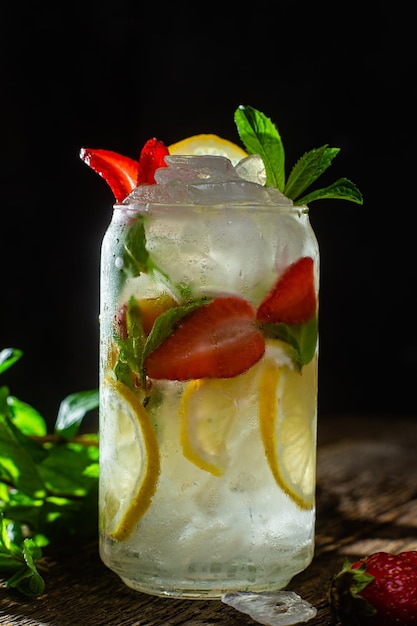 Cold lemonade with mint and lemon and ice on a dark background