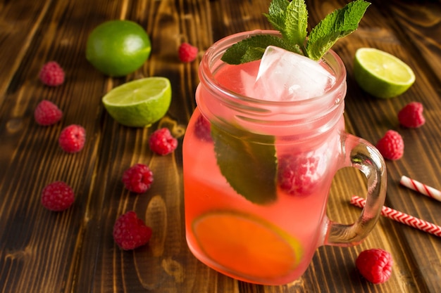 Cold lemonade with raspberries, lime and mint