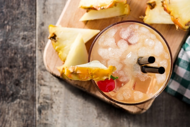 Cold mai tai cocktail with pineapple and cherry