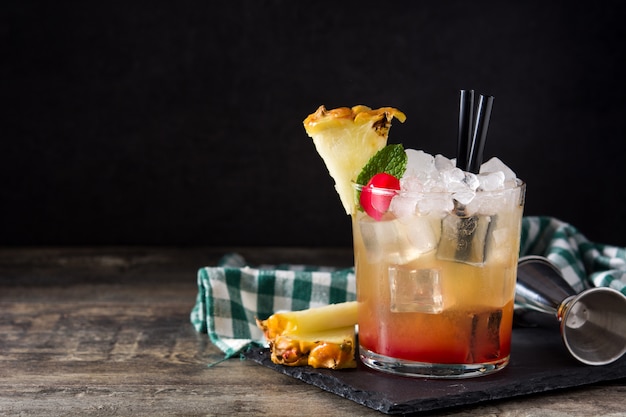 Cold mai tai cocktail with pineapple and cherry