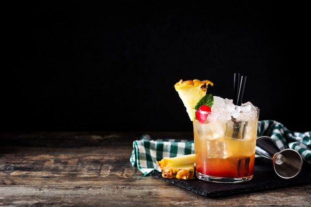 Cold mai tai cocktail with pineapple and cherry