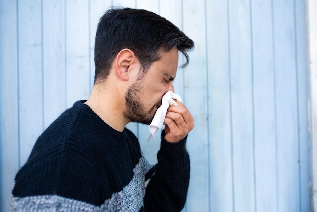 Cold man blowing his nose