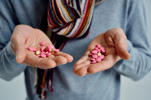 Cold man in a sweater with pills in hand health problems
isolated background