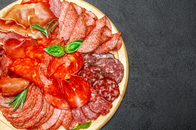 Cold meat plate with salami and chorizo sausage on wooden board