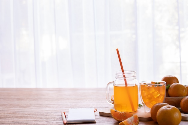 Cold Orange juice and Sliced orange on wood table.