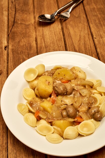 Foto zuppa di funghi con insalata di pasta fredda, pancetta di patate