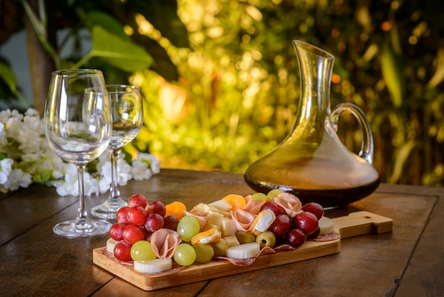 Cold platter and wine glasses on a wooden table.