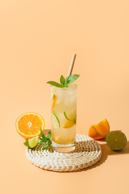 Cold and refreshing lemonade or cocktail with orange and lime slice.