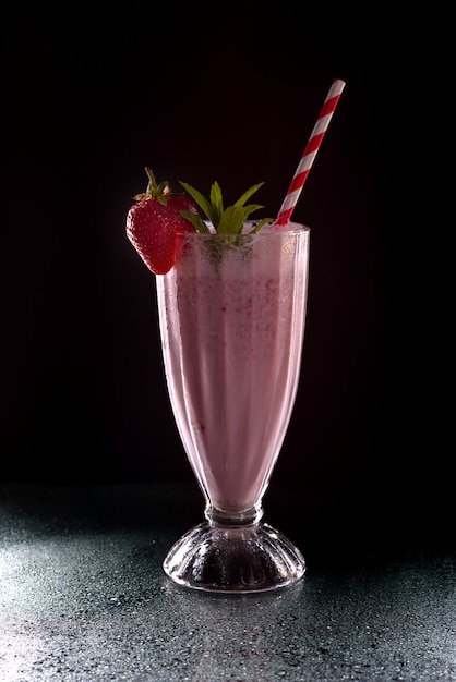 Ghiaccio freddo rinfrescante della fragola fresco con il tubo del cocktail su fondo nero