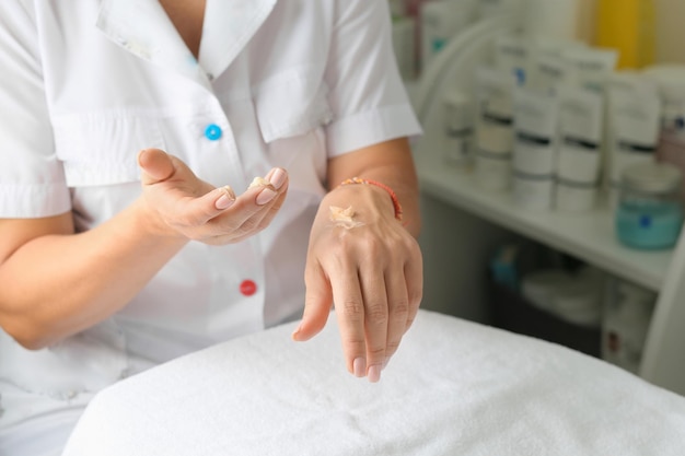 Photo cold season hands skin protection closeup woman applying protective cream on hands