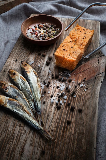 Foto pesce affumicato a freddo su una vecchia tavola di legno con spezie