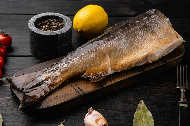 冷たい燻製魚のマスまたはサーモンセット、黒い木製のテーブルの背景に