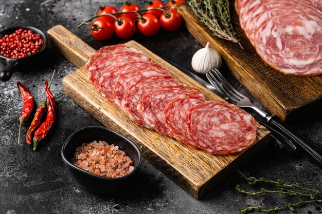 Cold smoked meat slices prosciutto set, on black dark stone table background