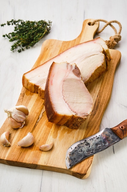 Cold smoked pork belly on wooden cutting board