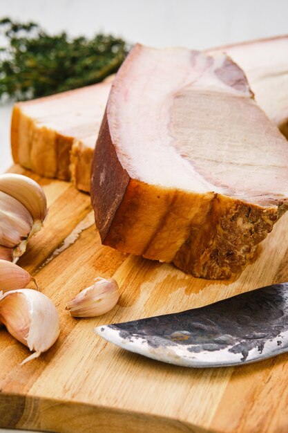 Cold smoked pork belly on wooden cutting board